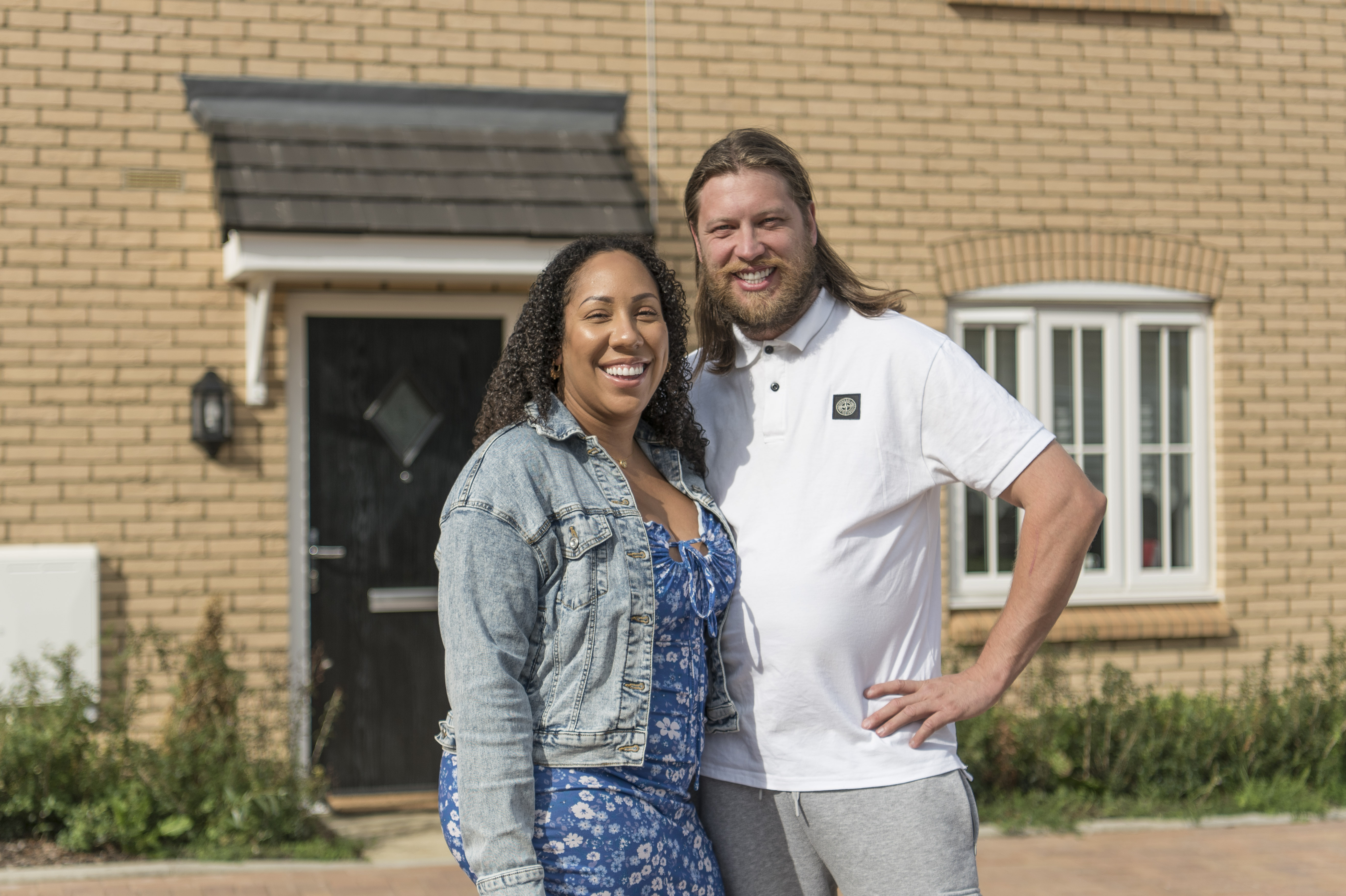 Young Couple Smiling Outside Home Homeowners