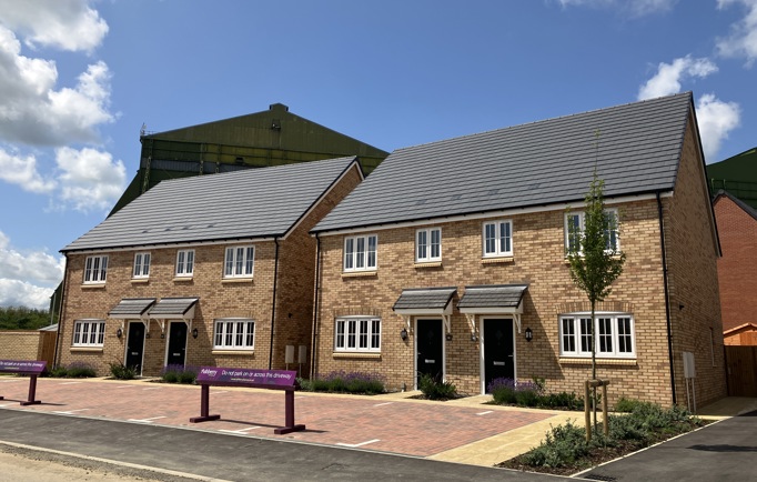 A newly buit development showing four homes with black doors