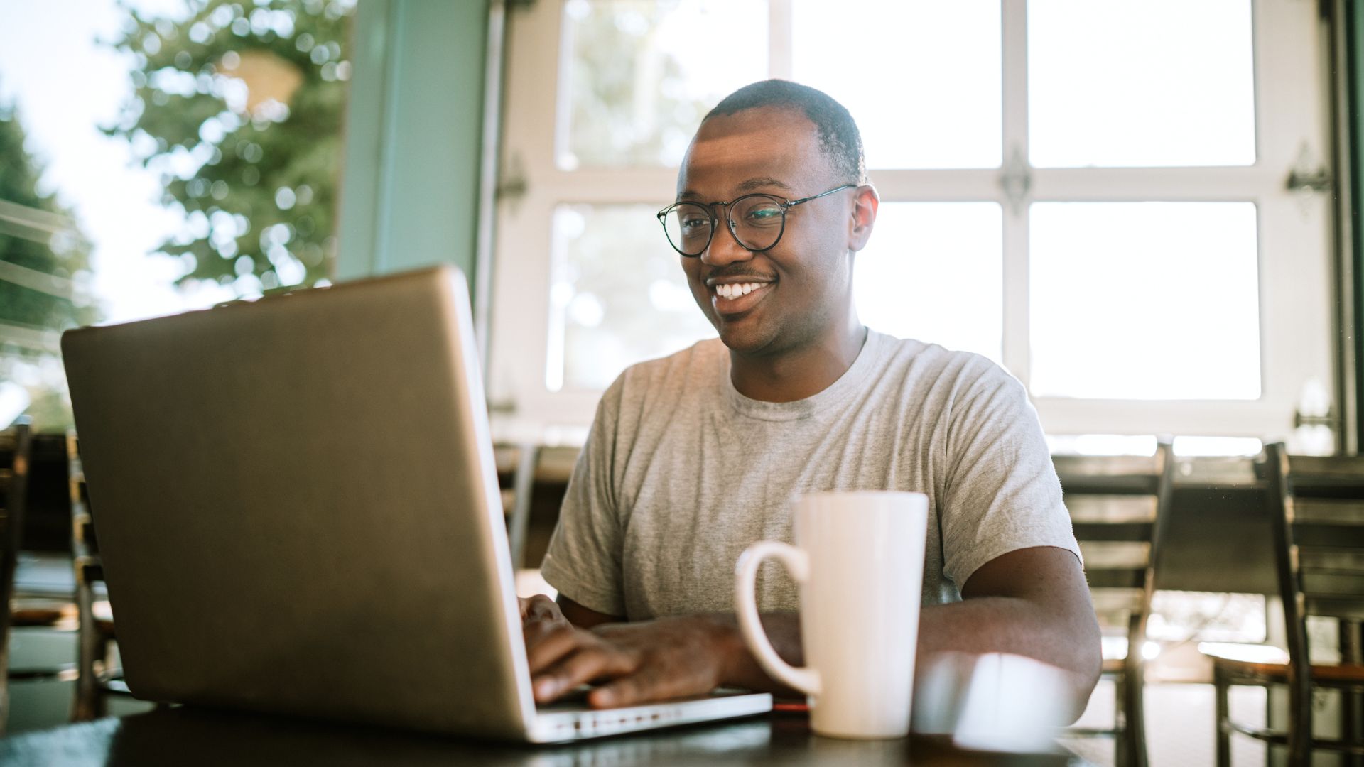 Man Working On Laptop From Cafe