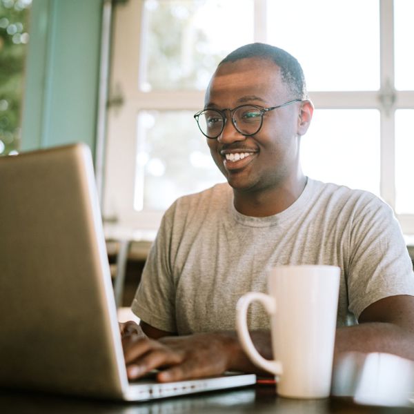 Man Working On Laptop From Cafe