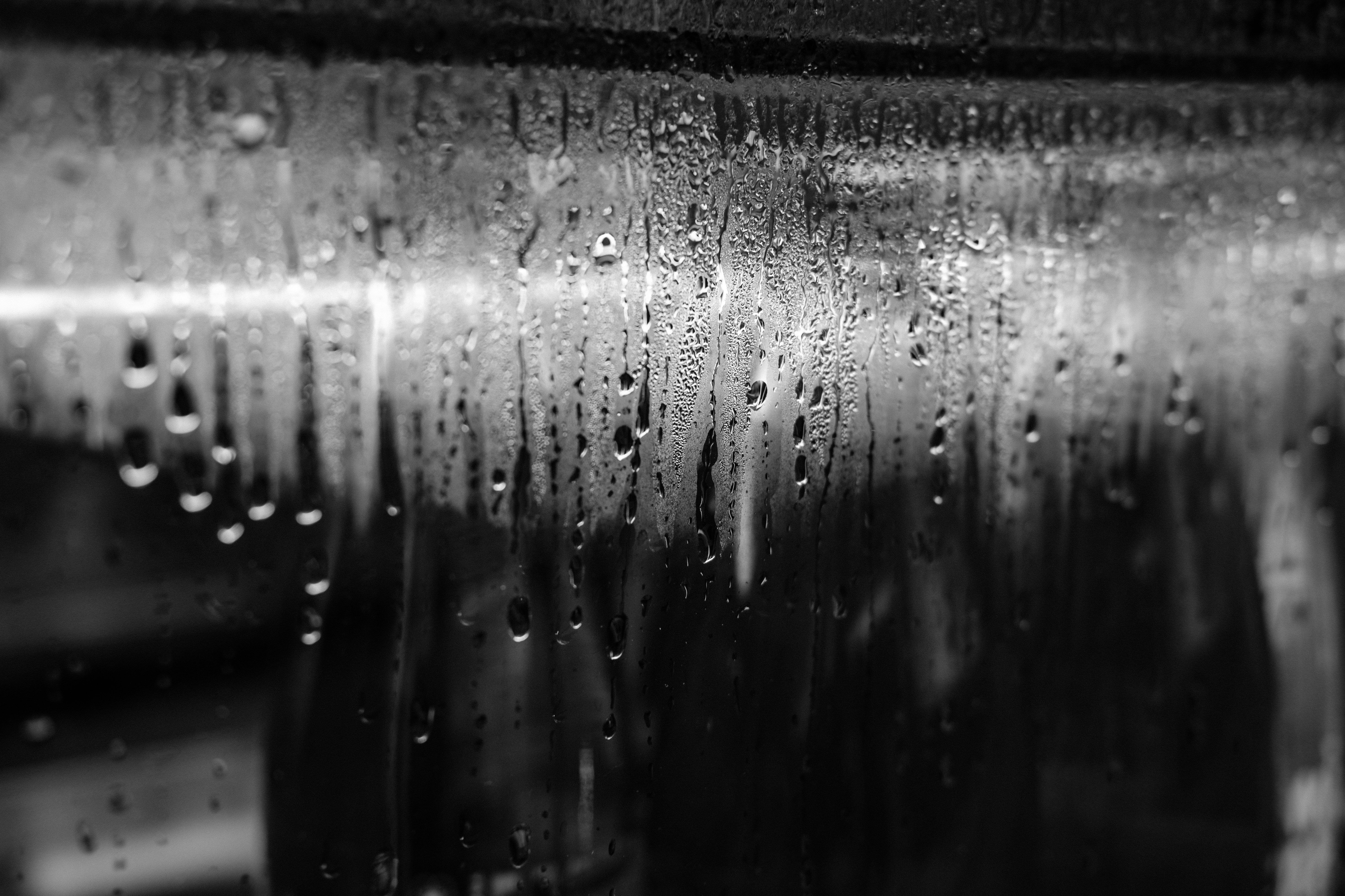 Black and white shot of water droplets running down glass