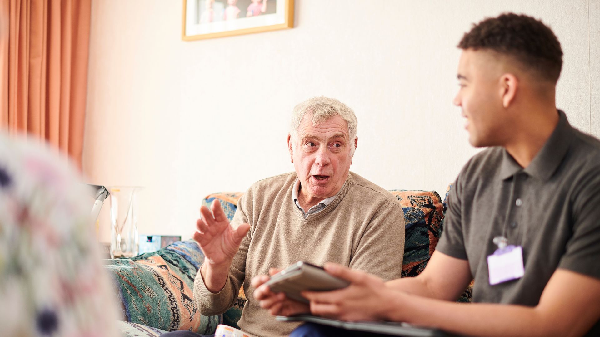 Man And Colleague Sat On Sofa Talking